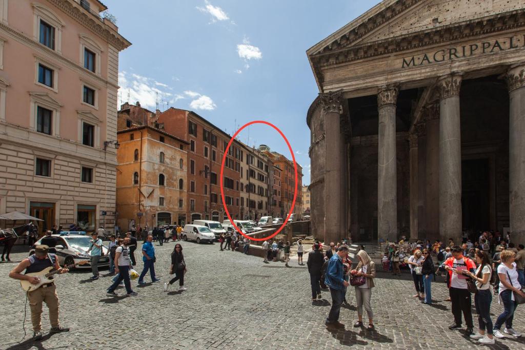 a group of people standing in a street with a red circle at A Window on Pantheon in Rome