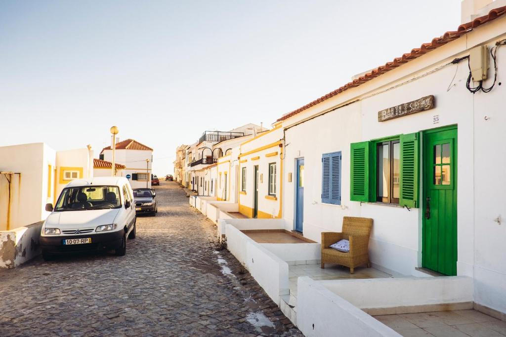 un coche aparcado en una calle al lado de los edificios en Balili Surf House, en Baleal