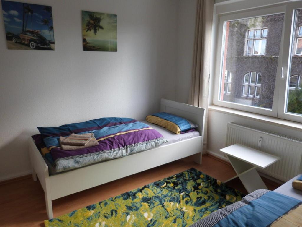een kleine slaapkamer met een bed en een raam bij Wohnung im Zentrum des Ruhrgebiets in Castrop-Rauxel