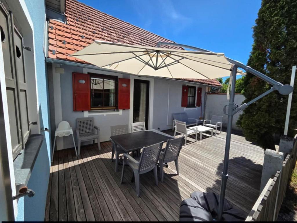 a wooden deck with a table and an umbrella at Terme Čatež - Family apartments with pool tickets in Čatež ob Savi