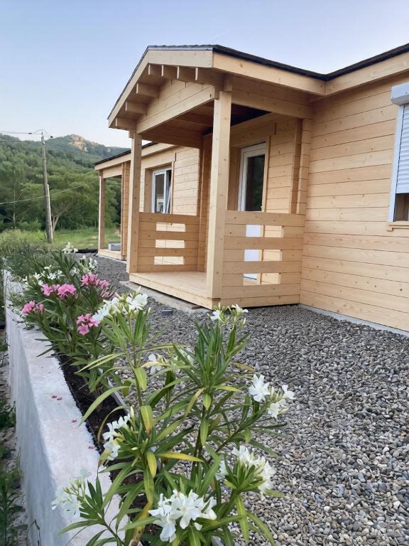 a small building with flowers in front of it at Au pied du plateau in Campagne-sur-Aude