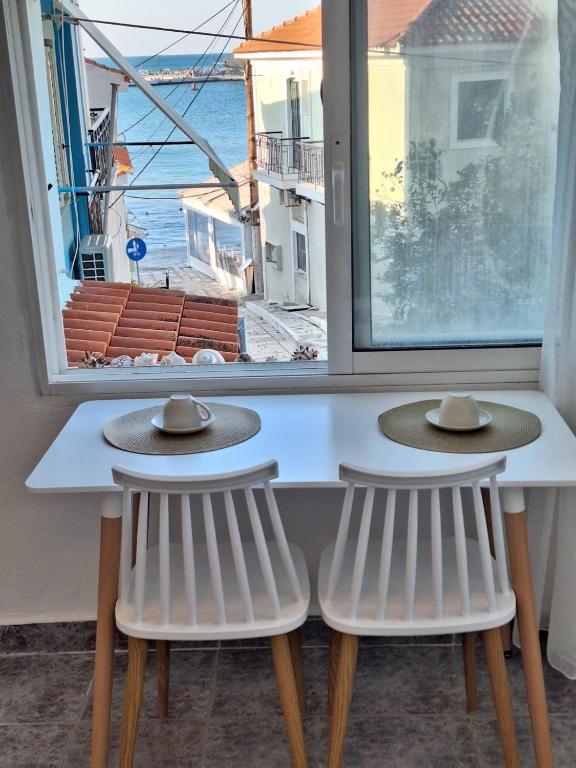 two hats sitting on top of a table in front of a window at Perla in Pythagoreio