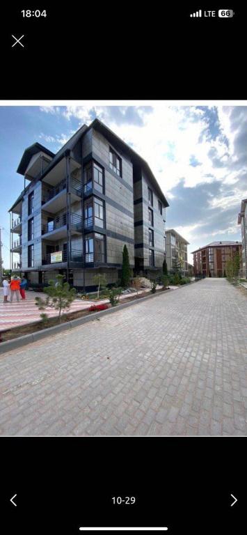 a large apartment building on a brick street at Likefront Apartment Issyk-Kul in Bosteri