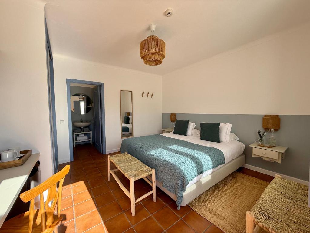 a bedroom with a bed and a table at O Monte da Estrada in Zambujeira do Mar