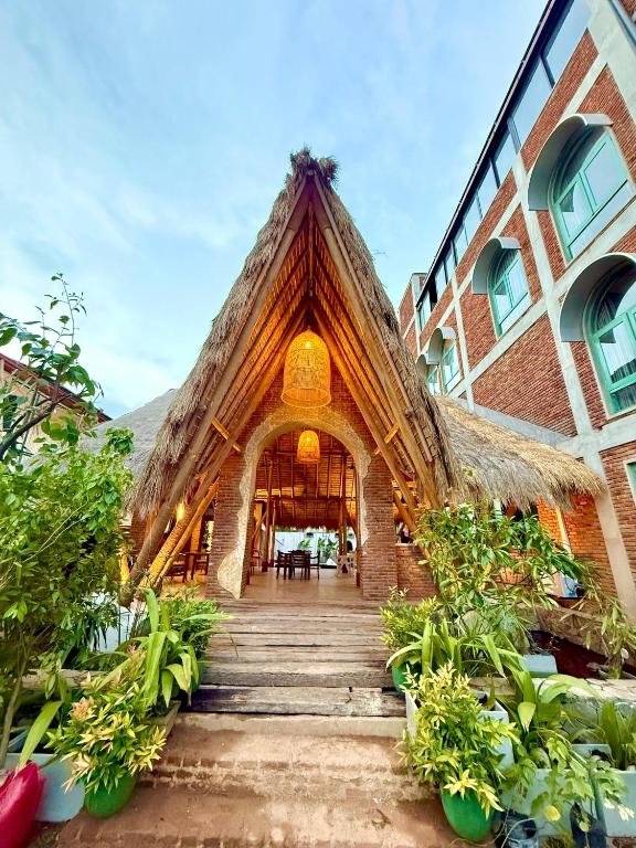 a building with a thatched roof and stairs in front at Hotel Catamaran Bay by Ayur Ayur in Negombo