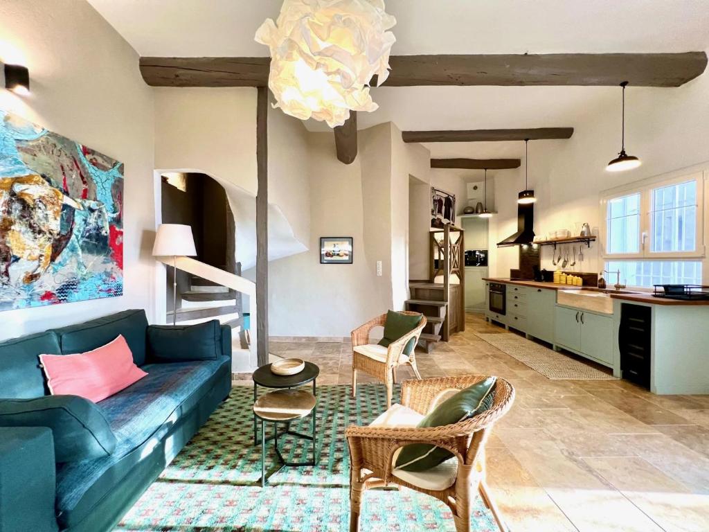 a living room with a blue couch and chairs at La petite fontaine in Bédoin