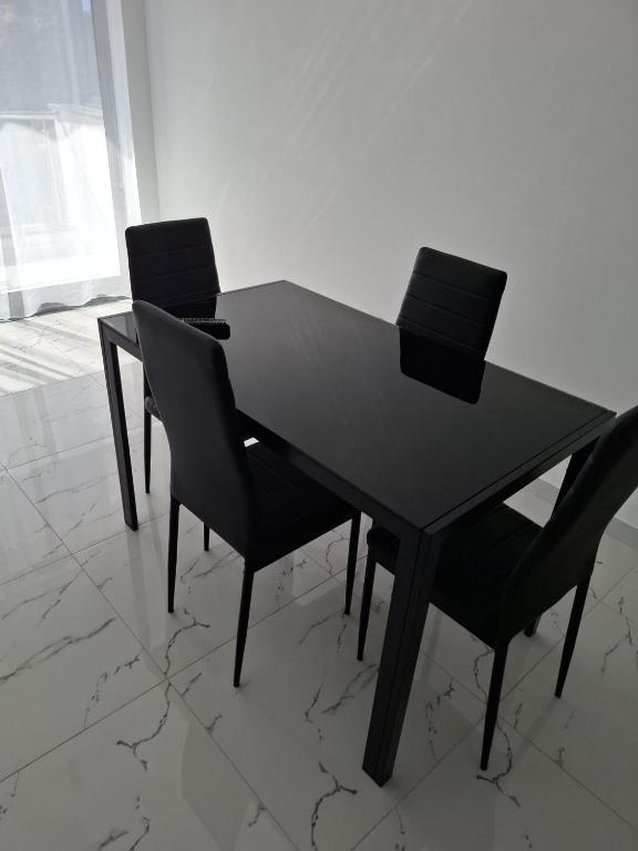 a black table with four chairs in a room at Chambre Double dans spacieux appartement in Tarrafal