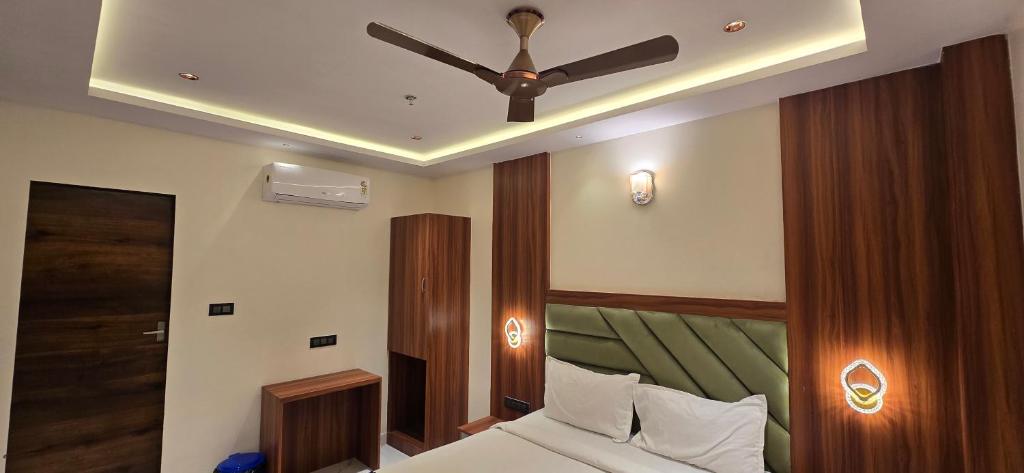 a bedroom with a bed with a ceiling fan at Hotel Sunrise Muzaffarpur in Muzaffarpur