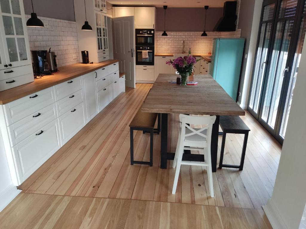 a kitchen with a wooden table and white cabinets at Ferienhaus in Graal-Müritz in Graal-Müritz