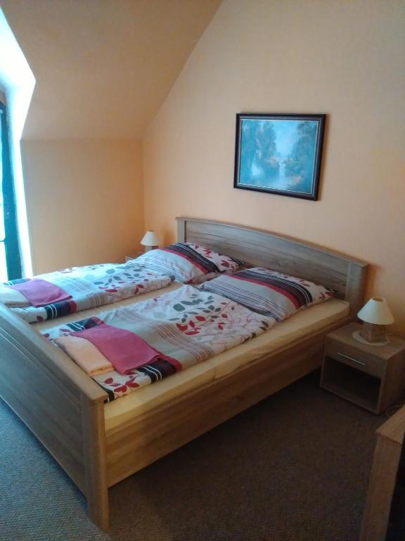 sypialnia z łóżkiem z drewnianą ramą w obiekcie Restaurace a pension První Mlýn Chomutov w mieście Chomutov