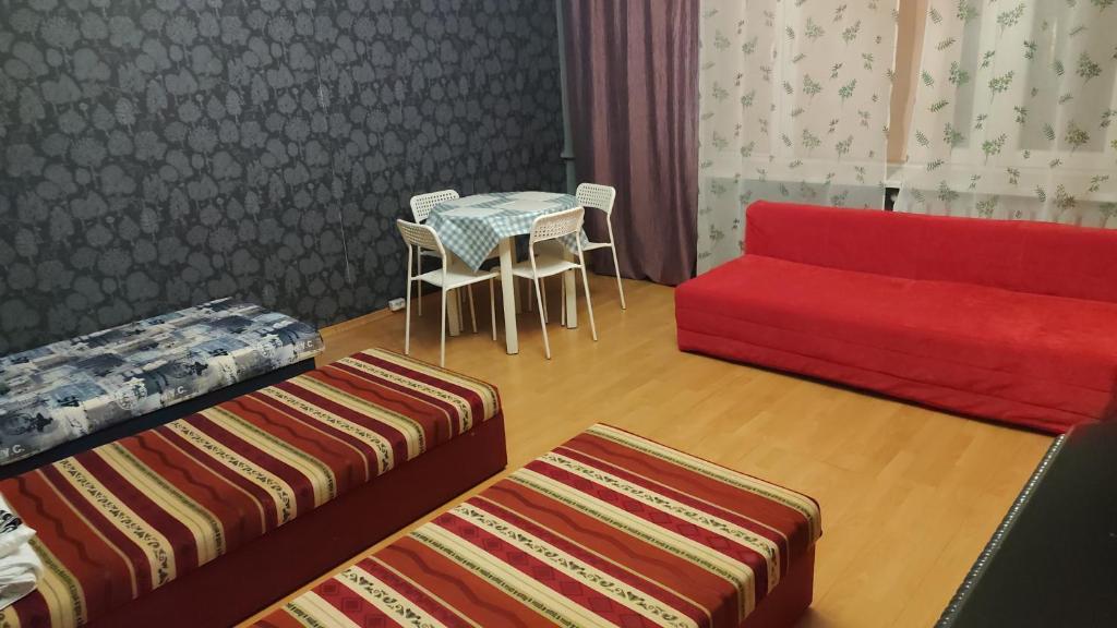 a living room with a red couch and a table at FEIDUM quarters rooms in Trzebinia