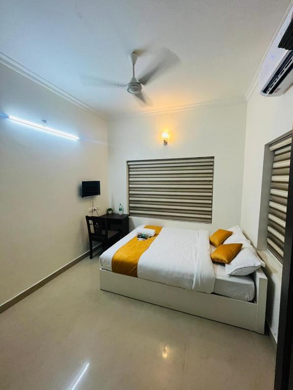 a bedroom with a bed and a desk in it at A22service villa in Cochin