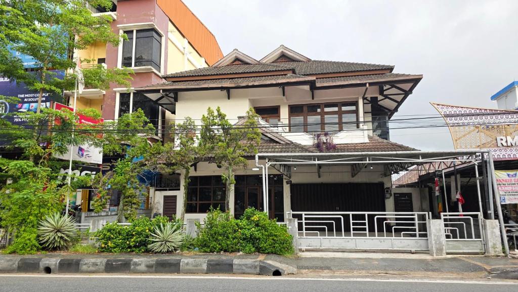 a house with a porch and chairs in front of it at Rumah Mewah Johar in Pontianak