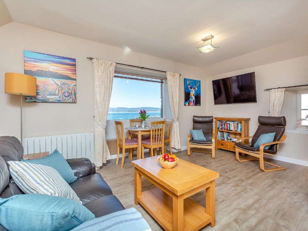 a living room with a couch and a table at Harbour View in Cromarty