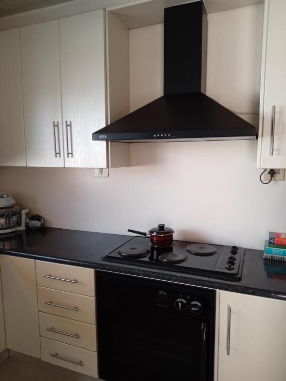 a kitchen with a stove and a black counter top at Nkotsha The Palace in Diepkloof