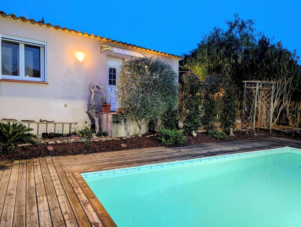 a swimming pool in front of a house at charmante maisonnette avec spa privatif in Zonza