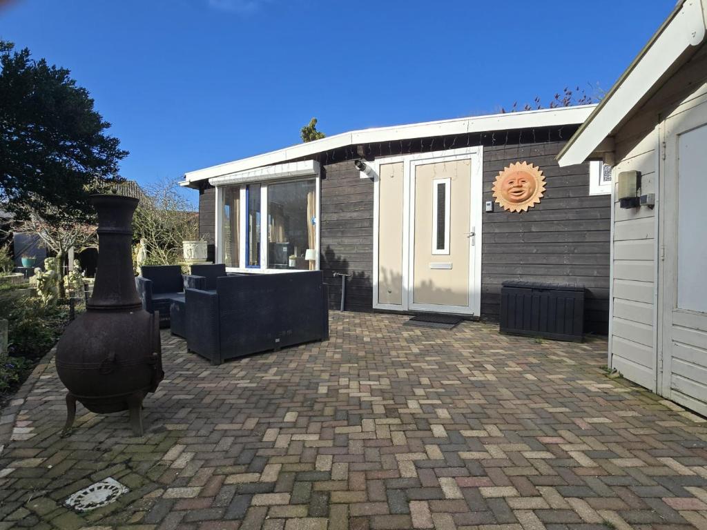a brick patio with a grill on the side of a house at Hooisma's Erf in Kampen