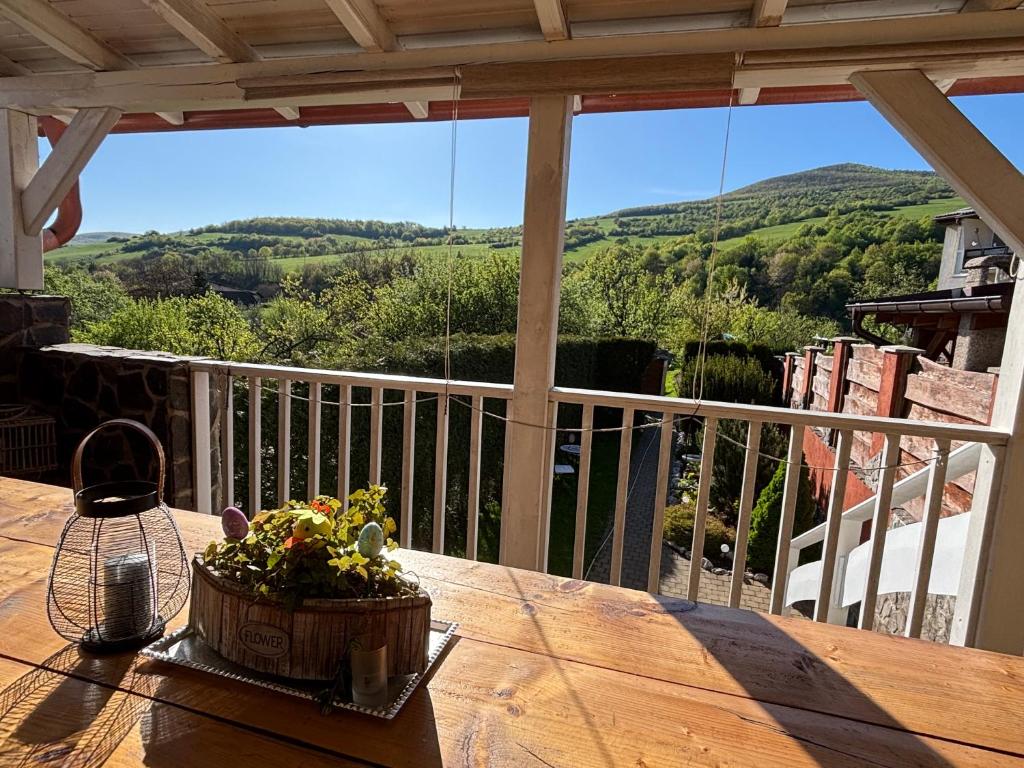 a wooden table with a basket of flowers on a balcony at Cottage House in Pača