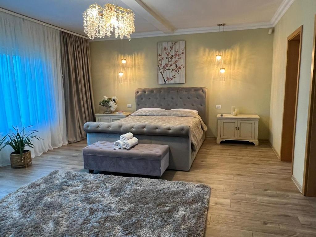 a bedroom with a bed and two ottomans at Vila DLK in Mamaia Sat/Năvodari