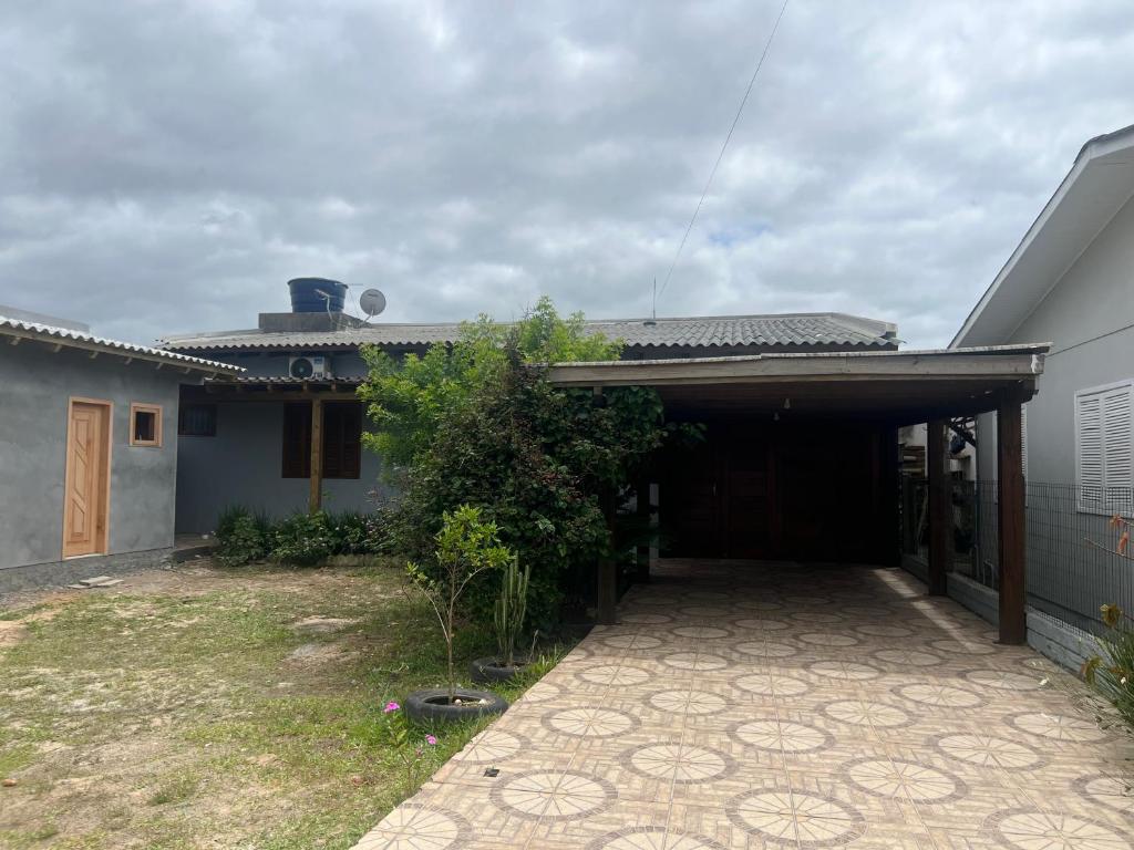 a house with a driveway leading to a garage at Residência Rosalaura in Balneário Gaivotas