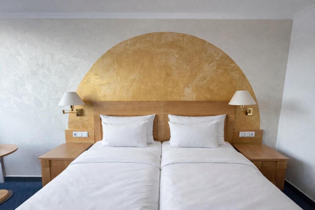 a bed with two white pillows in a room at Hotel gold Self-Check-In-Hotel Pfullendorf in Pfullendorf