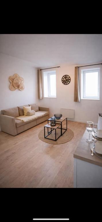 a living room with a couch and a table at Joli T2 proche parc expo in Mulhouse