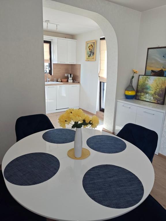 a white dining room table with a vase of flowers on it at Trend Apart in Burgas