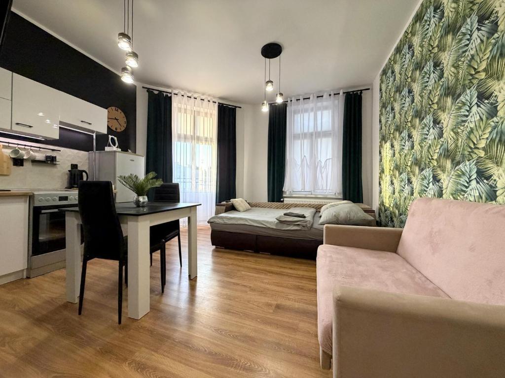 a living room with a bed and a table and a couch at w Centrum in Inowrocław