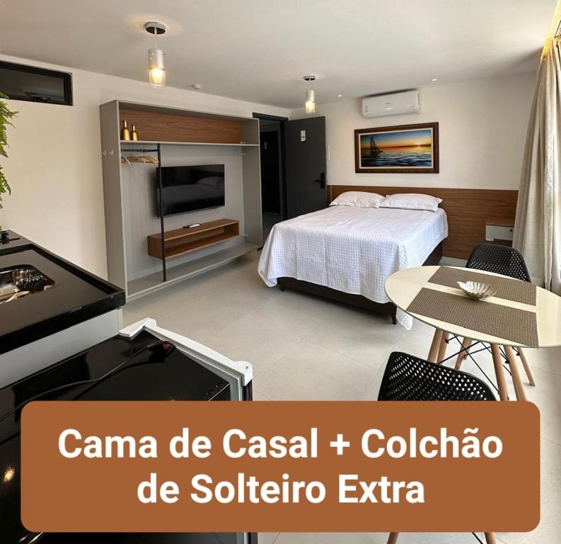 a bedroom with a bed and a television and a table at Bessa Flat Conforto à 180m do Mar - Storey Luxor in João Pessoa