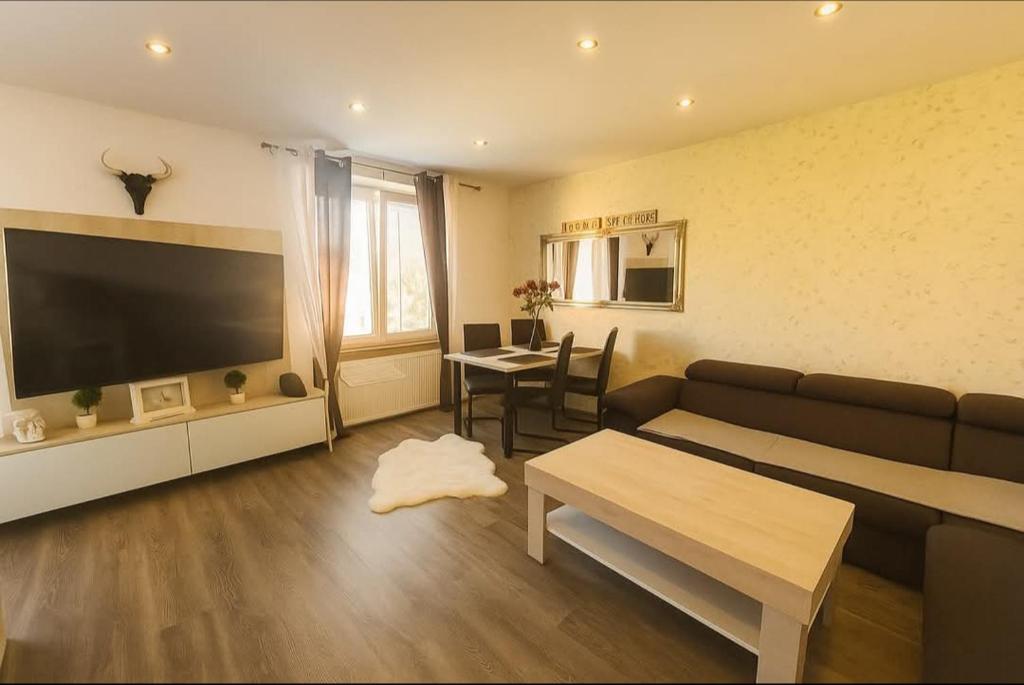 a living room with a couch and a table at Apartmán PP Tatry in Jezersko