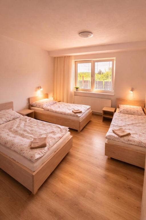 a room with three beds and a window at Pohoda Stay in Revúca