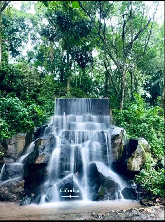 a waterfall in the middle of a forest at Calmira Boutique Stay in Kegalle