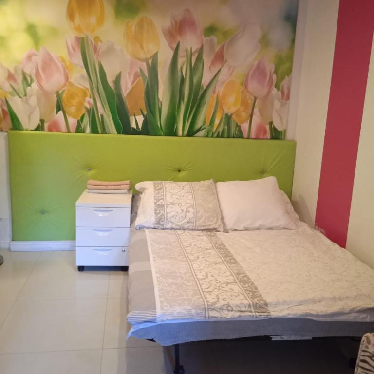 a bedroom with a bed and a painting of tulips at Ester in Będzin