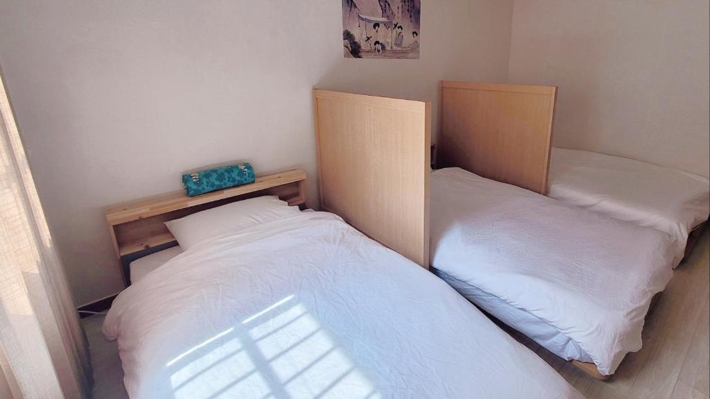 two beds in a small room withermottermottermottermott at Hanyang Healing House - 외국인 전용 in Seoul