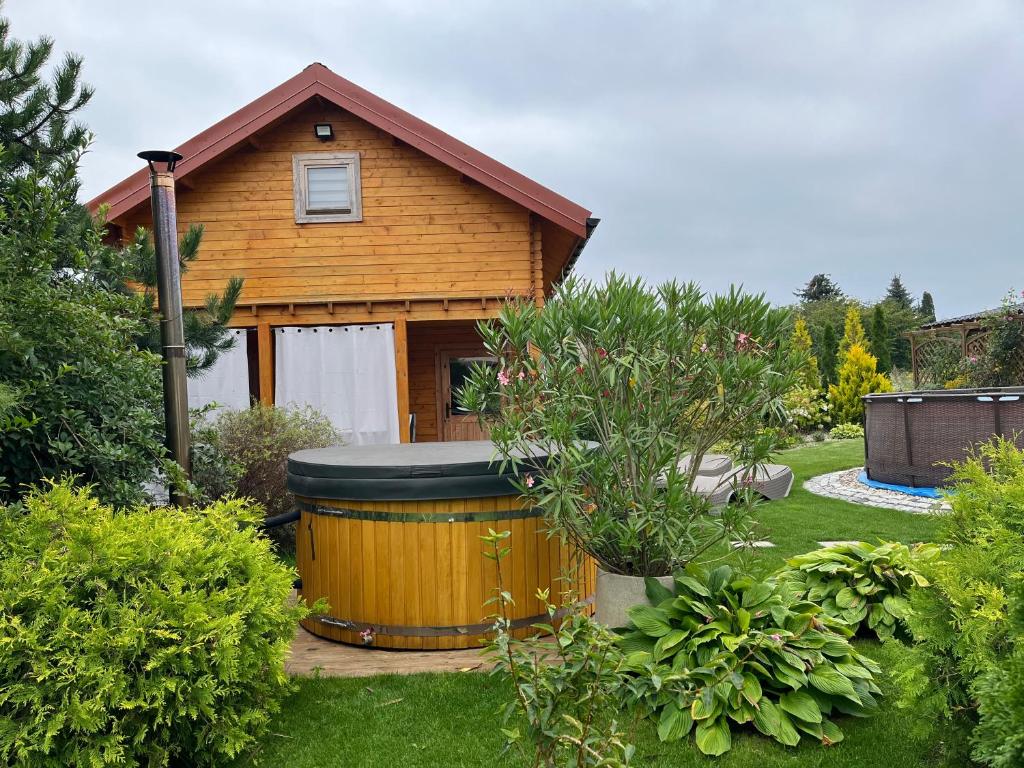 a house with a large barrel in a yard at Domek u Emi jakuzzi Wilkasy Giżycko in Wilkasy