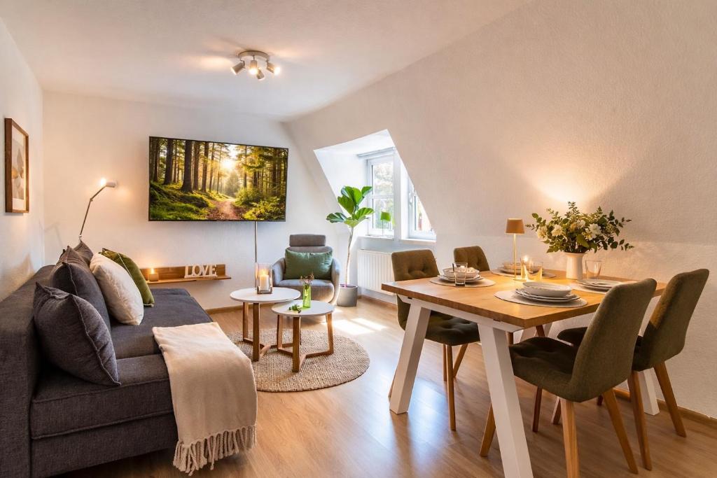 a living room with a couch and a table at ErzGlück Modernes Dachgeschoss-Apartment I nahe Altstadt I Stellplatz & Waschmaschine in Neuwelt