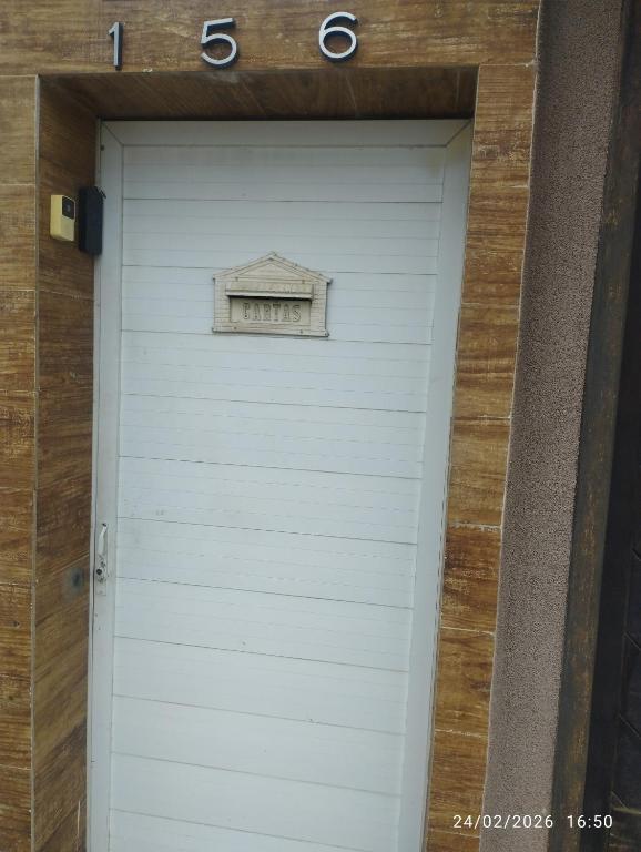 a white garage door with a sign above it at Quitinete 5 Itaguaí in Itaguaí