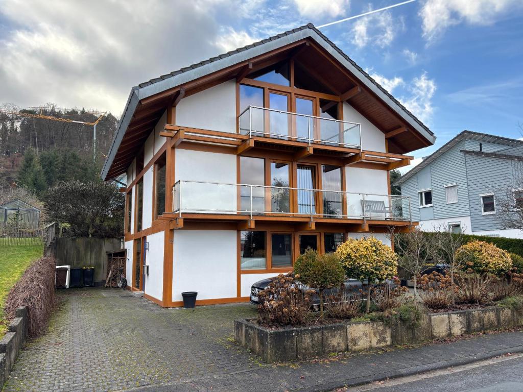 ein Haus mit einem Balkon an der Seite in der Unterkunft Ferienwohnung Schillerstaße in Haiger