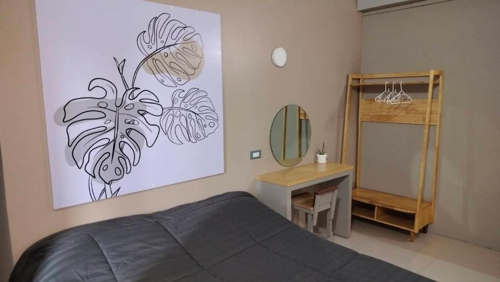 a bedroom with a bed and a desk and a mirror at The City in Ban Si Than