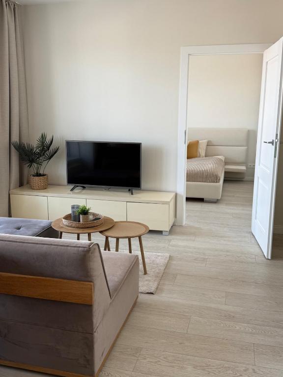a living room with a couch and a tv at Bird's eye Apartment with sea view 18th floor in Klaipėda