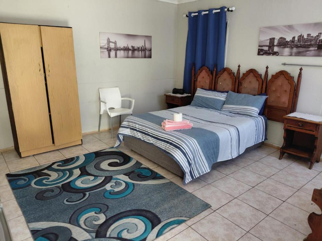 a bedroom with a bed and a table and a chair at Germiston Residential Motel in Germiston