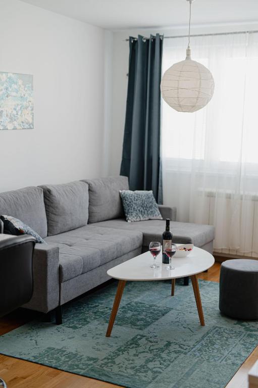 a living room with a couch and a table at SK Blue apartment in Lukavica