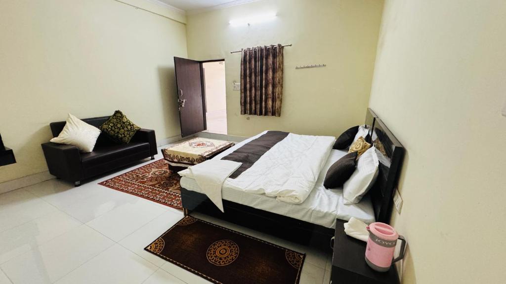 a bedroom with a bed and a couch at Hotel Orchha Inn in Orchha