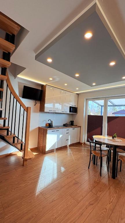 a kitchen with a table and a dining room at Domki Premium Nad Bałtykiem in Wodnica