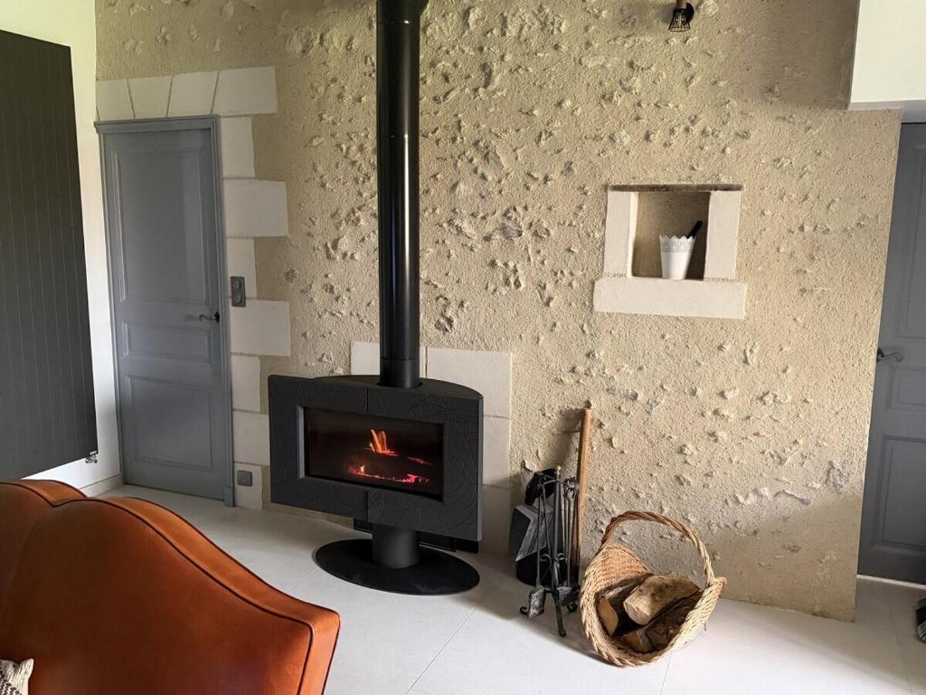 a fireplace in a living room with a stove at Villandry - Domaine de l'Augeonnière in Villandry