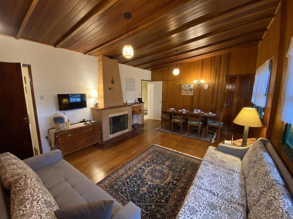 a living room with a couch and a fireplace at Campos do Jordão à moda antiga in Campos do Jordão