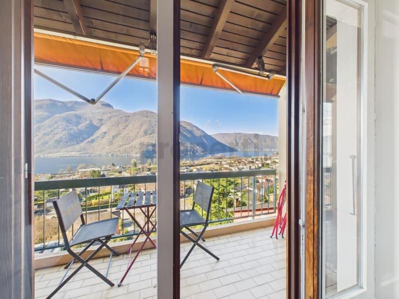 a balcony with a table and chairs and a view of the mountains at La fornace lago in Melano
