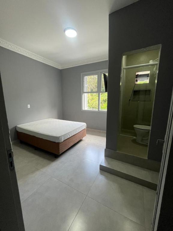 a bedroom with a bed and a window and a toilet at Museu Plaza Hotel in São Paulo