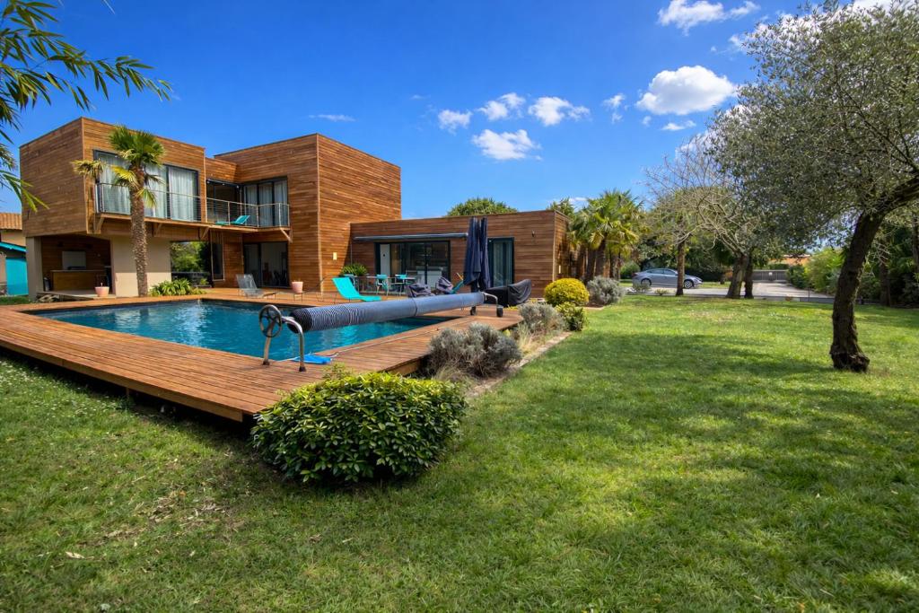 a house with a swimming pool in front of a yard at Cap Ferret Villa Océane in Lège-Cap-Ferret
