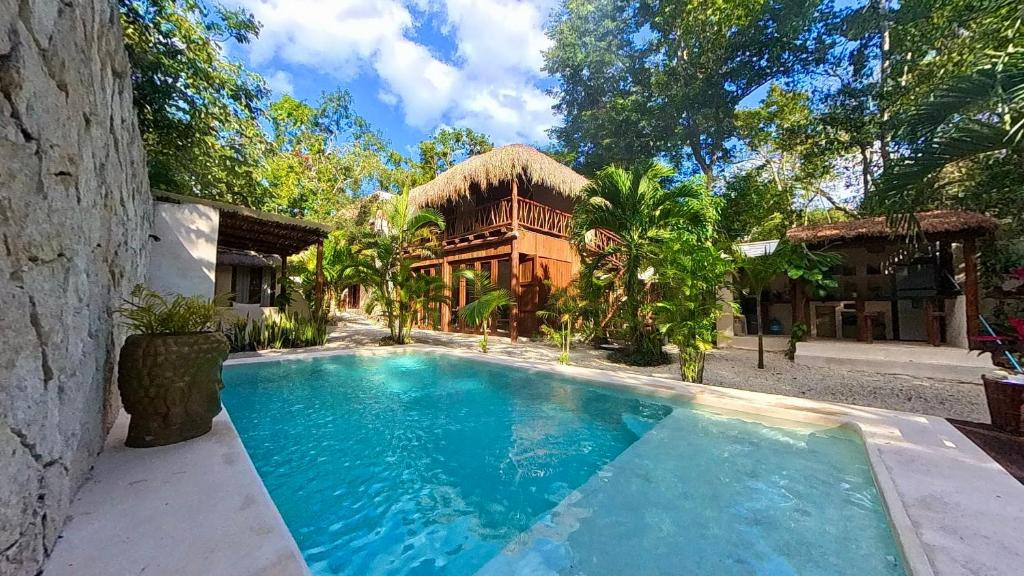 ein Swimmingpool vor einem Haus in der Unterkunft Lodge Tzunum Jade in Tulum